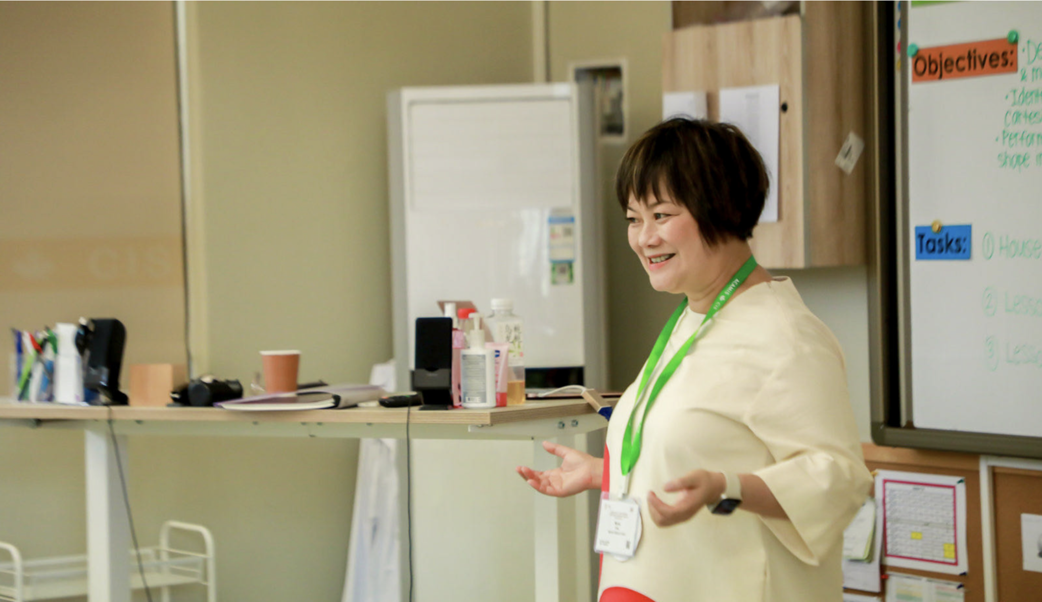 Dr Minna Chau - Accredited Clinical Psychologist smiling giving a parents workshop in a Hong Kong International school wearing a visitor batch